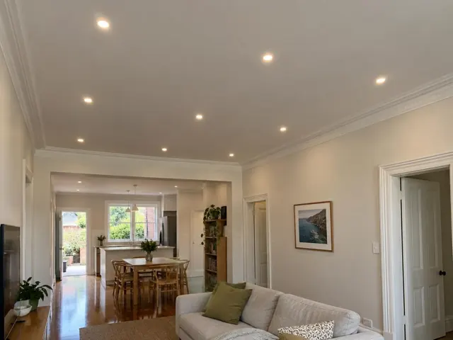 Living room and dining area with flush ceiling downlights in a cream interior in Dulwich Hill